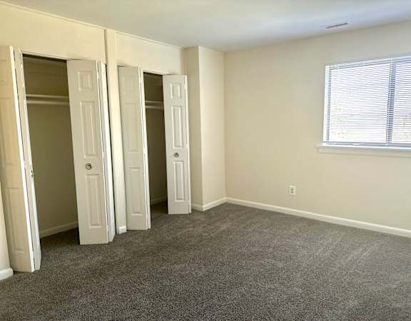 an empty room with three doors and a window