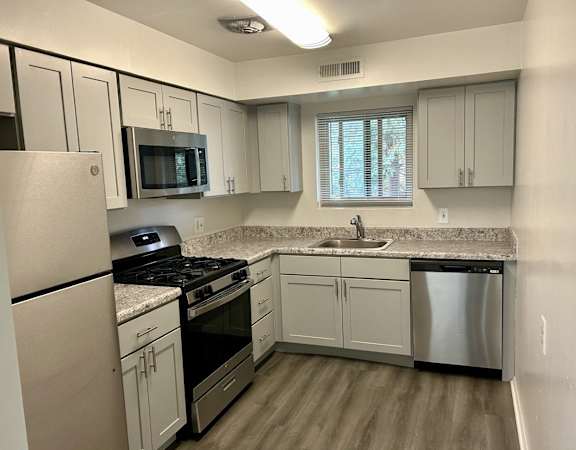 a kitchen with white cabinets and stainless steel appliances