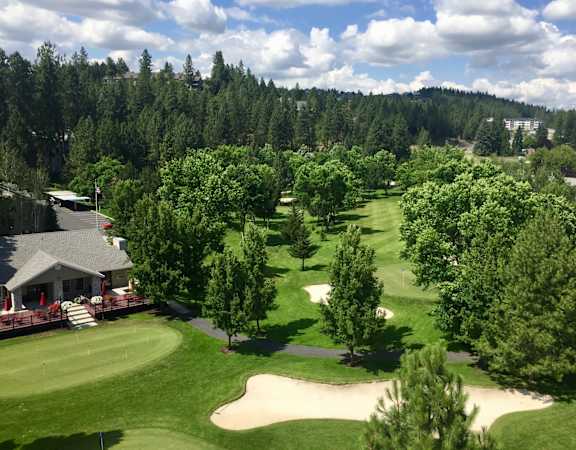 A golf course with a green and a sand trap.