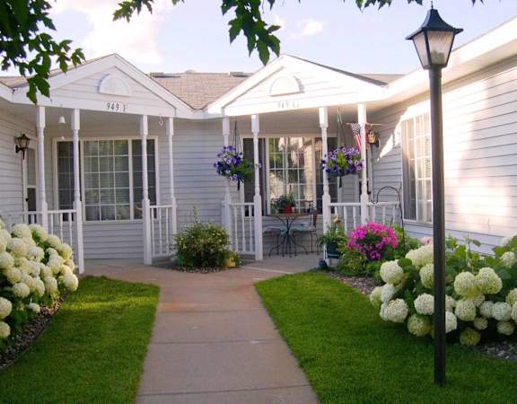 A white house with a porch and a lamp post.