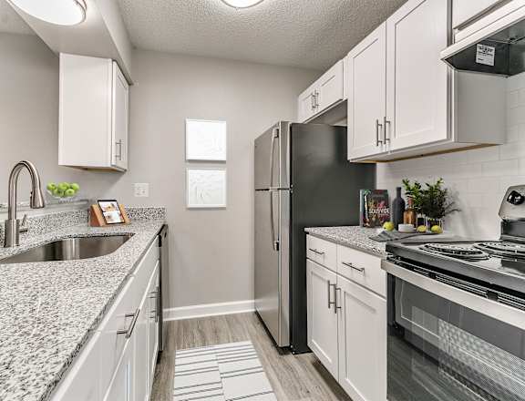 an updated kitchen with granite counter tops and stainless steel appliances