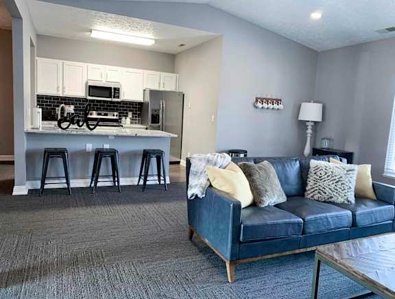 clubhouse with a couch and a kitchen with a bar