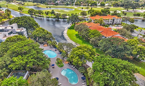 A bird's eye view of a resort with a swimming pool and a river.
