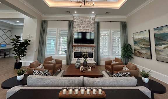 A living room with a grey sofa, a wooden coffee table, and a chandelier.