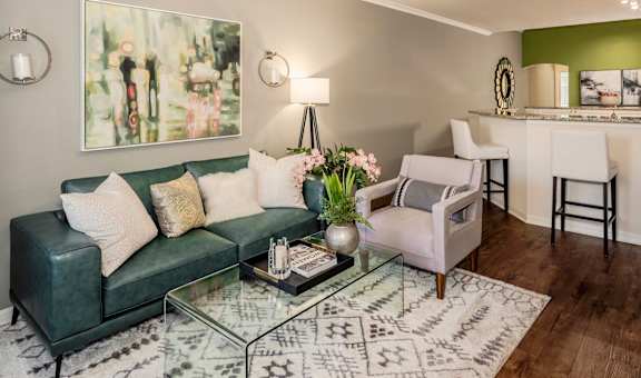 Stylish living room with sofa, accent chair, artwork, and glass coffee table