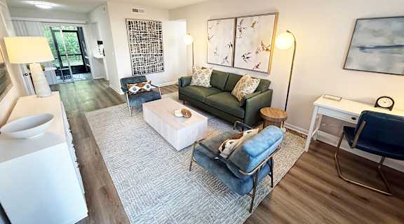 A living room with a green couch and a white coffee table.