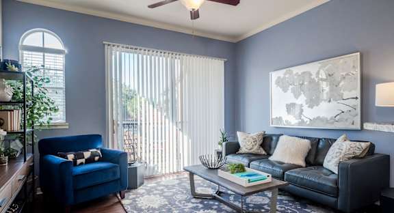 Living room with blue walls, leather sofa and balcony light