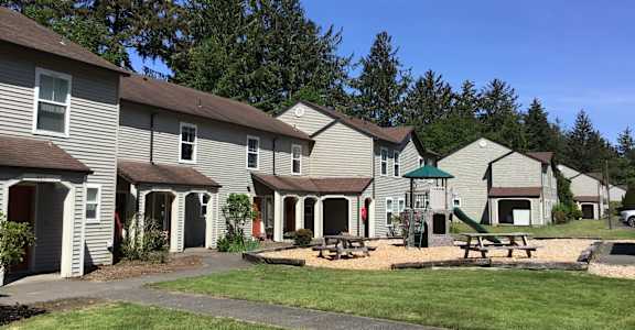 A row of houses with a green lawn in front.