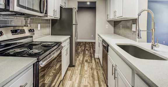 A kitchen with white cabinets and a black stove top oven.