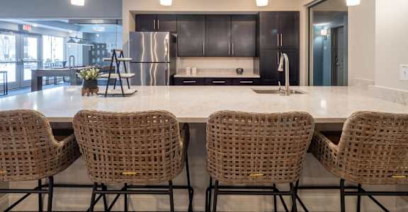 A kitchen with a table and chairs in front of a refrigerator.