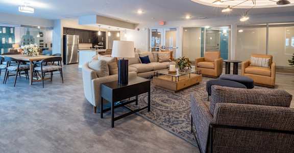 A spacious living room with a variety of seating options and a dining table.