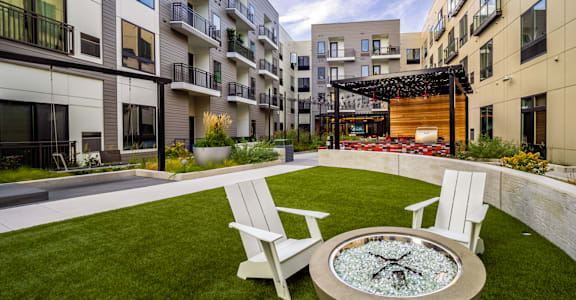 A modern courtyard with a fire pit and seating area at Center Square Lofts West, Allentown, PA