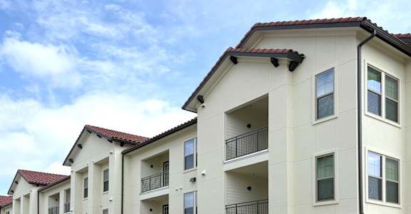 A row of apartment buildings with balconies and doors. at Northwoods, Texas, 77388