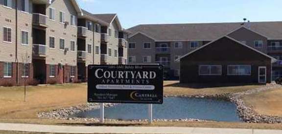a sign in front of Courtyard Apartments on Belsly apartment complex