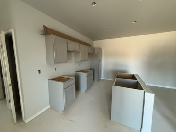 A room with white walls and cabinets is being renovated.