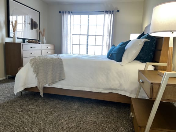 a bedroom with a bed and a dresser with a mirror on it