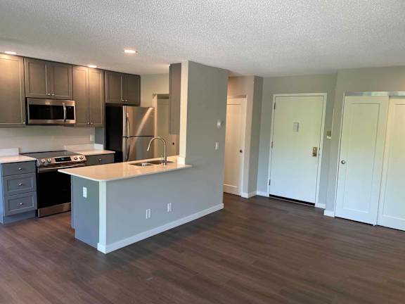 A kitchen with a white island and stainless steel appliances.
