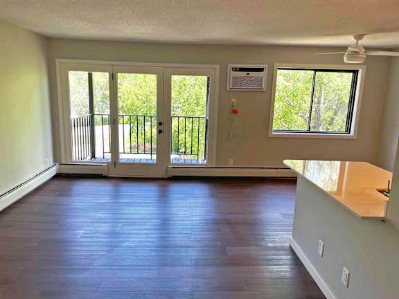 A room with a sliding glass door leading to a balcony.