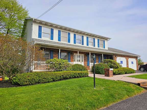A house with blue shutters and a white picket fence.