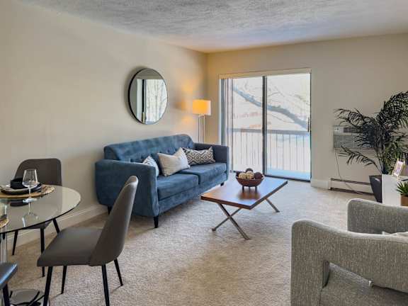 A modern living room with a television, a couch, and a potted plant.