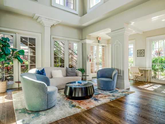 Elegant clubhouse seating area with large windows, plush chairs, and inviting design.