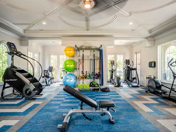 Spacious fitness center with stair climber, free weights, and functional training equipment.