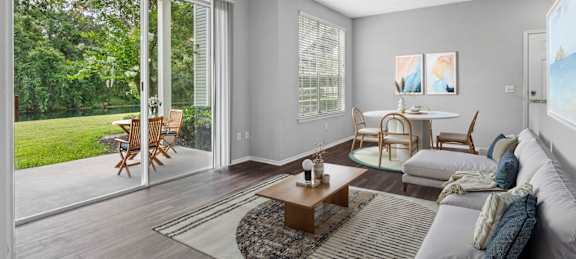 A living room with a ceiling fan and sliding glass doors.