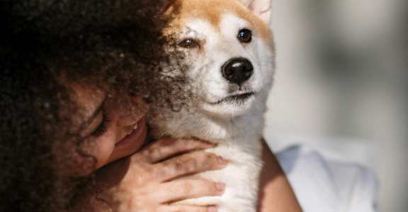 a woman holding a dog in her hands