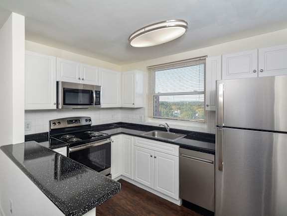 A modern kitchen with stainless steel appliances and white cabinets.