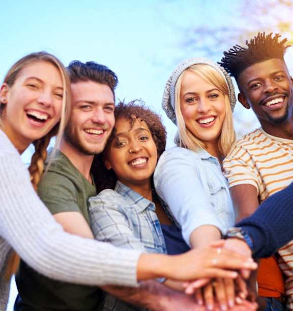 A group of people holding hands together in a circle.