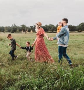 Young Family Walking Through Field