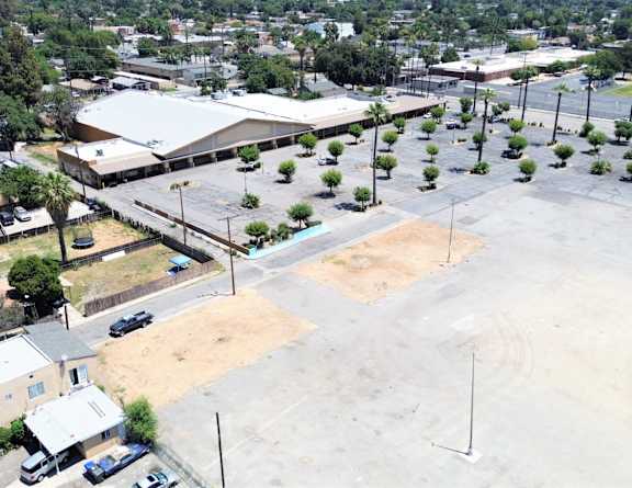 A parking lot is surrounded by buildings and roads.