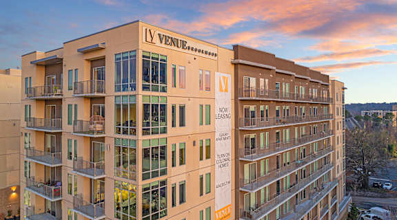 an apartment building with a sunset in the background