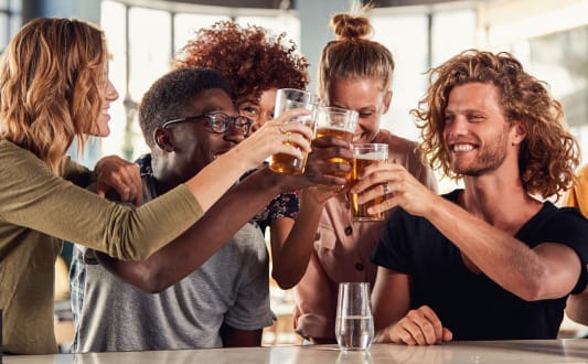 a group of friends drinking beer at a bar