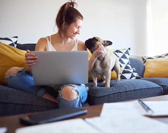 a woman and a girl sitting on a couch looking at a tablet