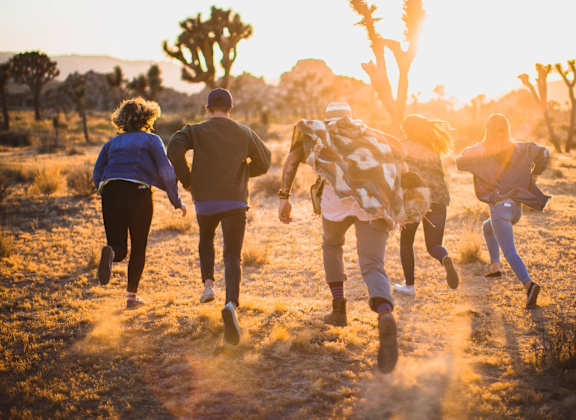 a group of people running in the desert