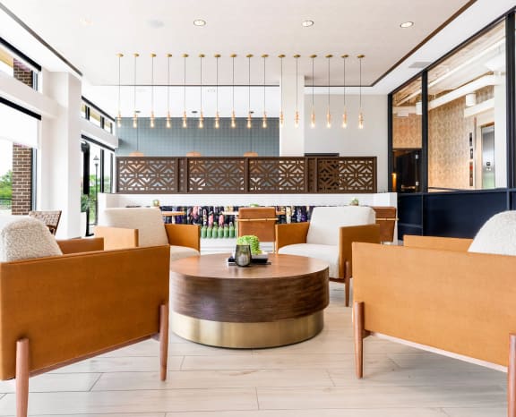 a lobby of a hotel with chairs and a table