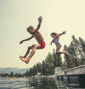 Kids Smiling and Jumping into Lake Together