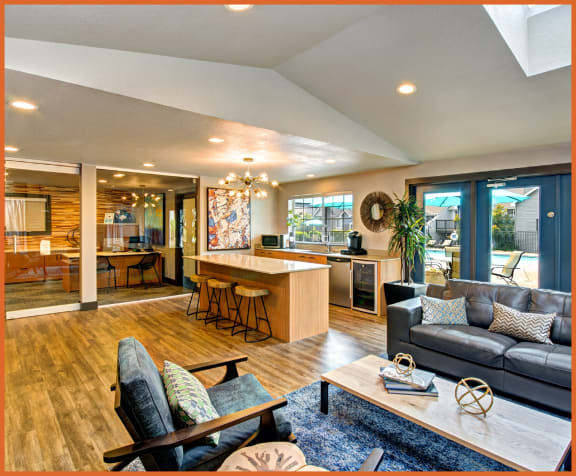 a spacious living room with a kitchen in the background and a couch and chair in the foreground