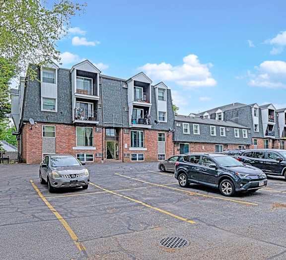A parking lot with cars and a building in the background.