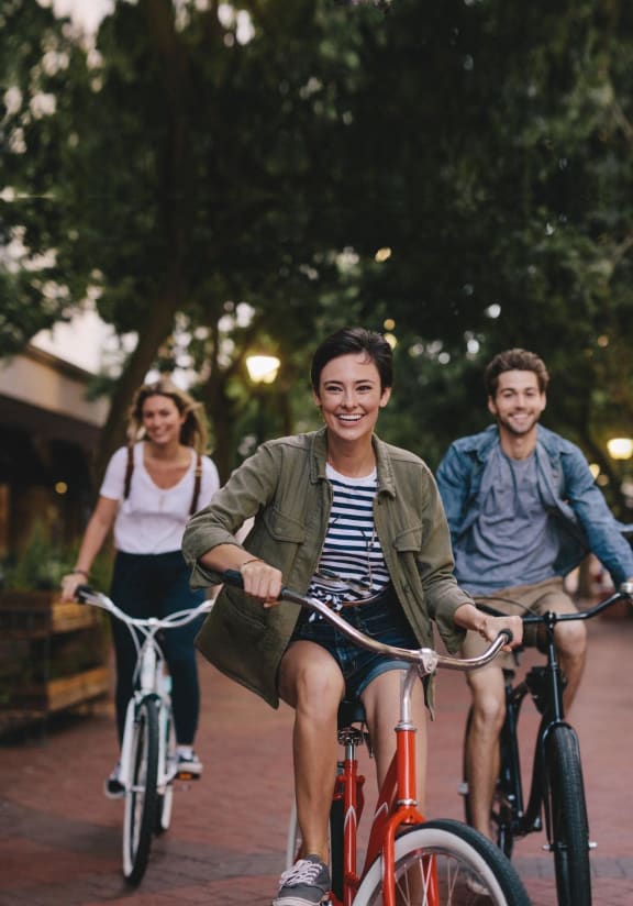 Friends Riding Bikes Together Smiling at Koi Apartments, Seattle, Washington