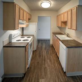 A kitchen with wooden cabinets and a white stove top oven.