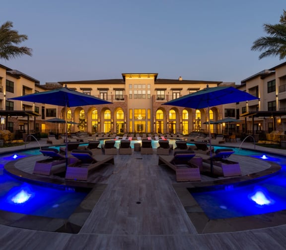 Berkshire Exchange pool area at night with water lit up. Located in Spring, Texas 77388