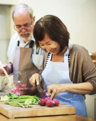 Man and Woman Smiling while Preparing Food