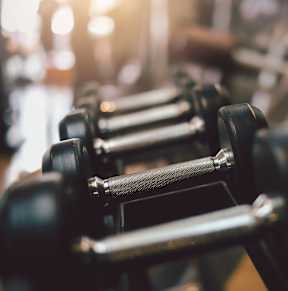 A close up of a black dumbbell in a gym.
