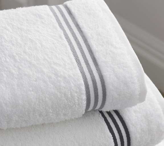 a white towel with black and white stripes on top of a bed