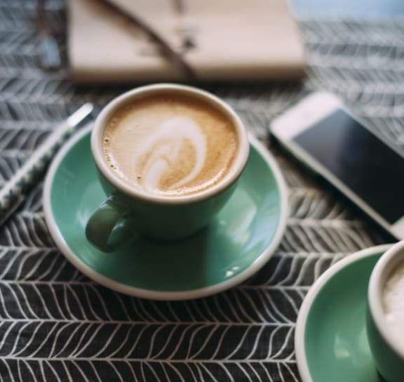 Cup of Coffee on Table Next to Cell Phone