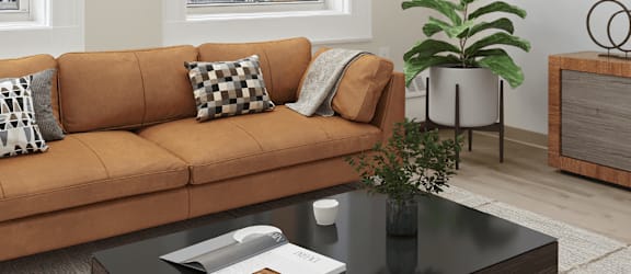 A living room with a brown couch, a coffee table, and a potted plant. at Chapman House, E. Boston, MA, 02128