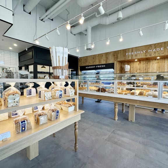 the interior of a bakery with tables and displays of food at Southpark on Whyte, Edmonton, AB