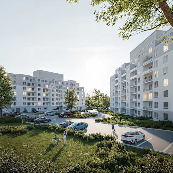 A modern apartment complex with cars parked in the driveway and people walking around.